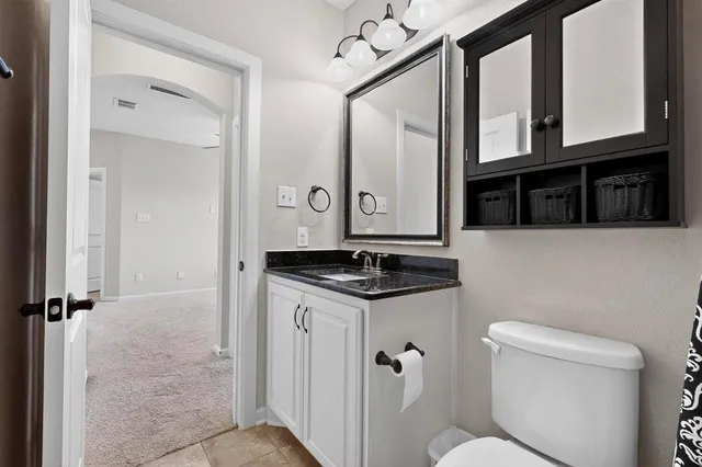 a bathroom with a granite countertop sink toilet and shower