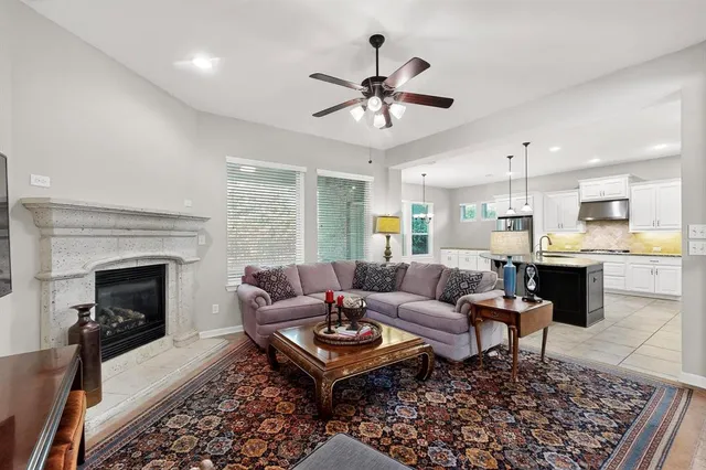 a living room with furniture a fireplace and a chandelier