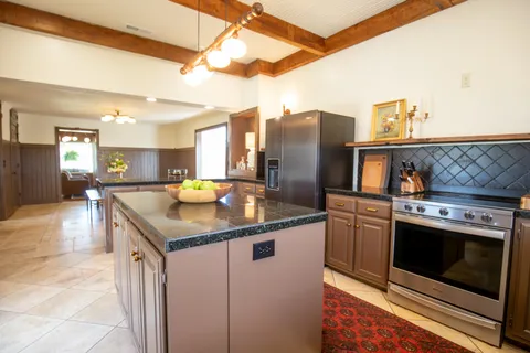 a kitchen with stainless steel appliances granite countertop a sink a stove and a refrigerator