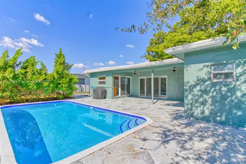 a view of house with swimming pool and yard