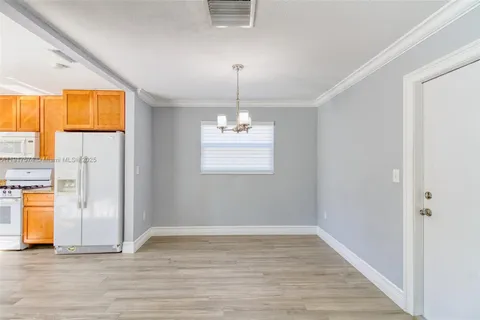 a large kitchen with a refrigerator a sink dishwasher a fireplace and wooden floor