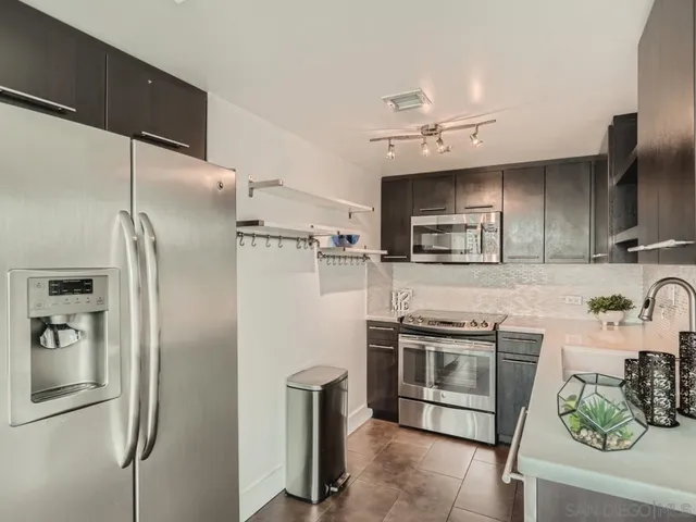 a kitchen with stainless steel appliances a refrigerator a sink a stove and cabinets