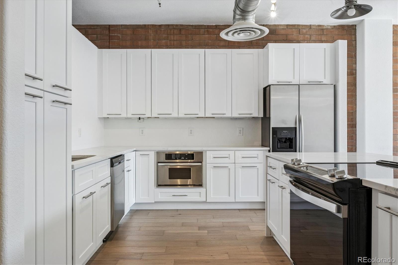 2245 Blake Street, Unit F Denver, CO 80205 - Photo 11 of 38 a kitchen with stainless steel appliances a stove a sink and cabinets