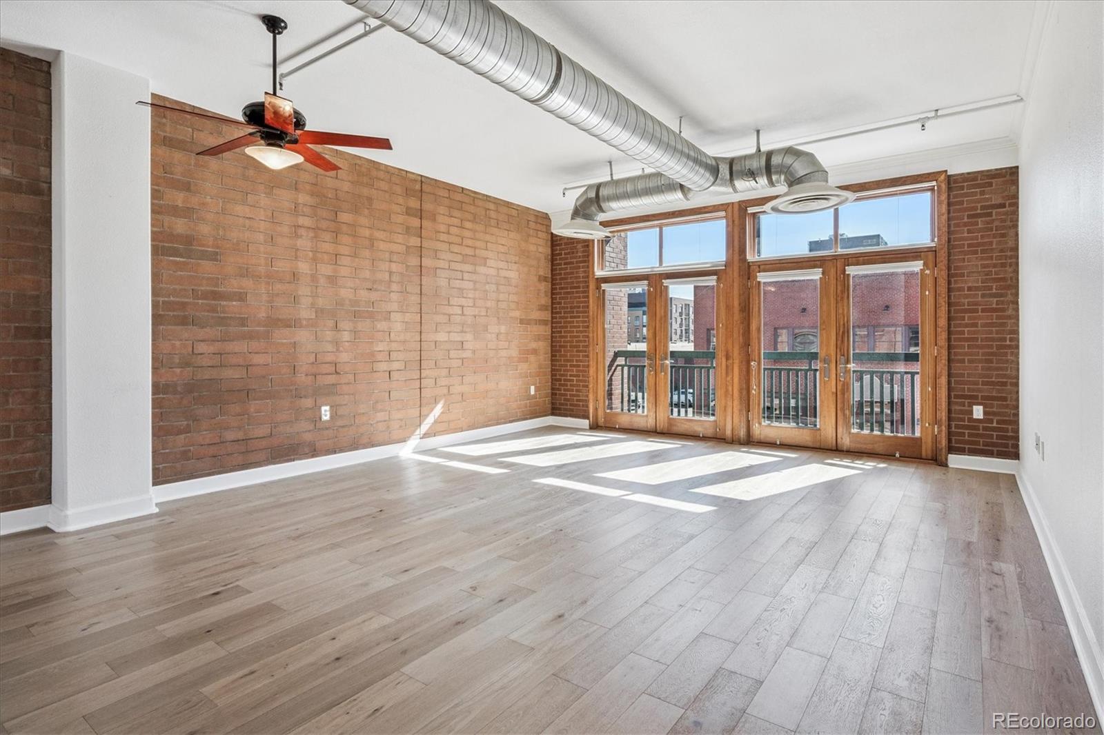 2245 Blake Street, Unit F Denver, CO 80205 - Photo 17 of 38 a view of an empty room with wooden floor and a window