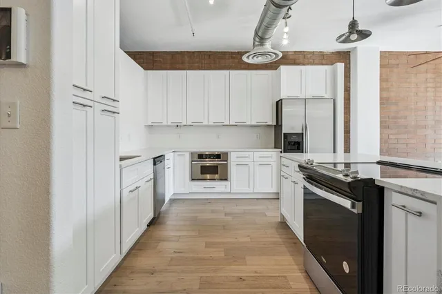 a kitchen with stainless steel appliances granite countertop a stove a sink and a refrigerator
