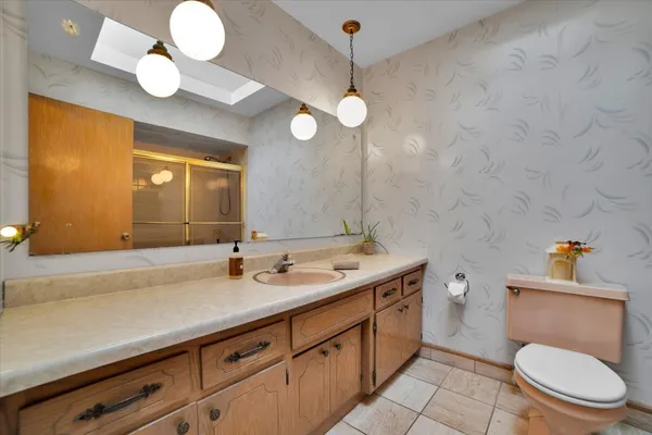 a bathroom with a granite countertop sink a toilet and a mirror