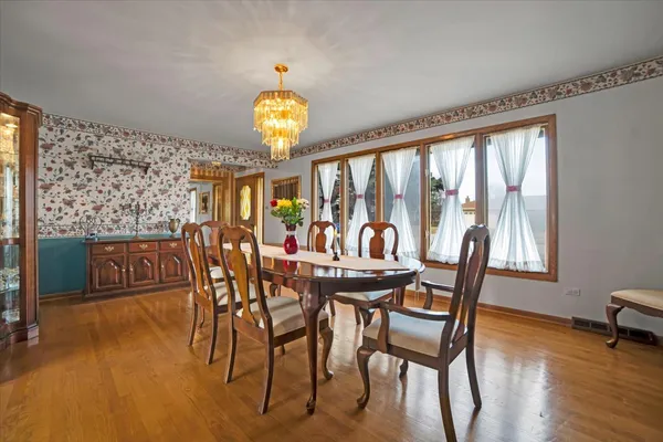 a view of a dining room with furniture a chandelier and wooden floor