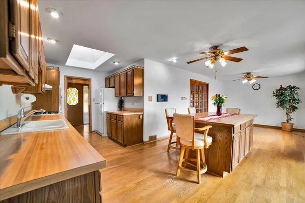 a living room with furniture a dining table with kitchen view and wooden floor