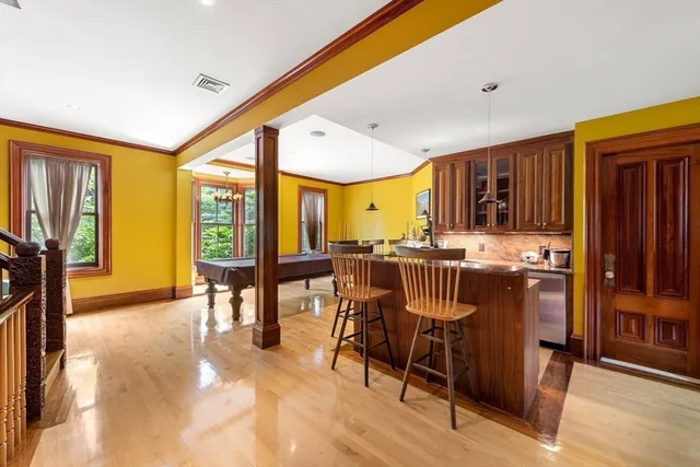 a kitchen with stainless steel appliances granite countertop dining table chairs and a refrigerator