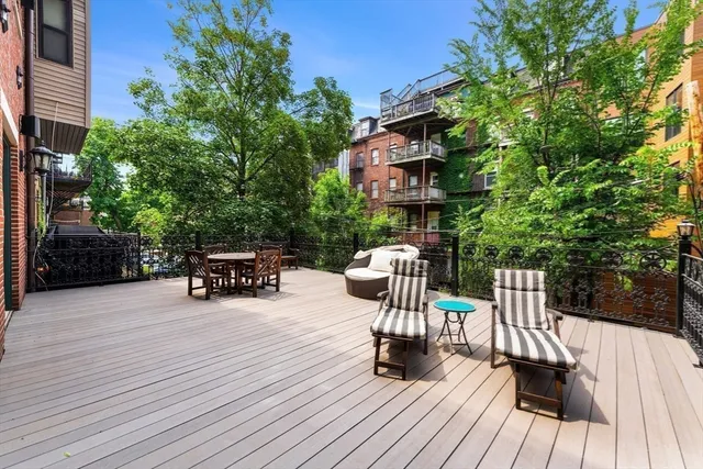 a view of roof deck with table and chairs and wooden floor
