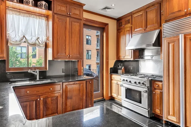 a kitchen with stainless steel appliances granite countertop a stove a sink and a refrigerator