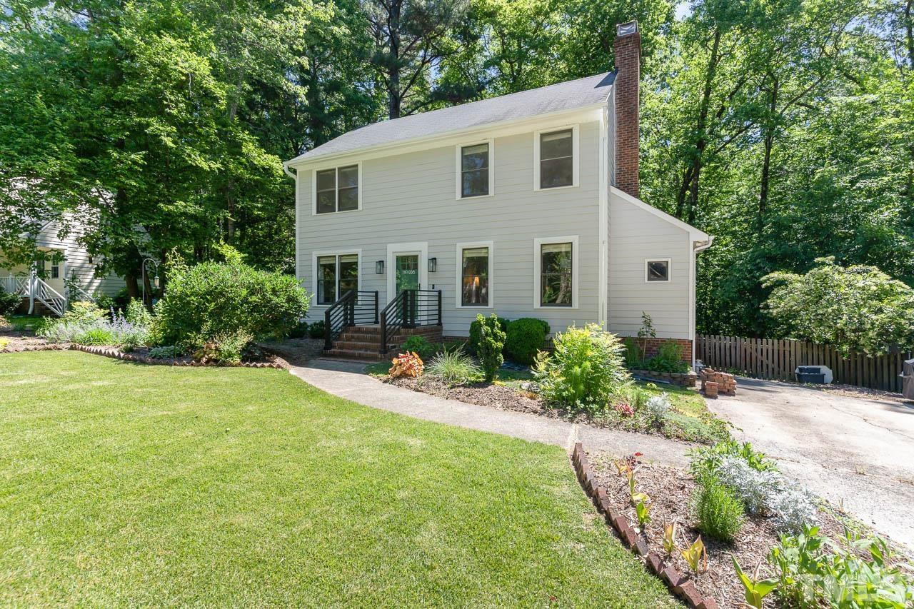a view of a house with a yard and lawn chairs with plants