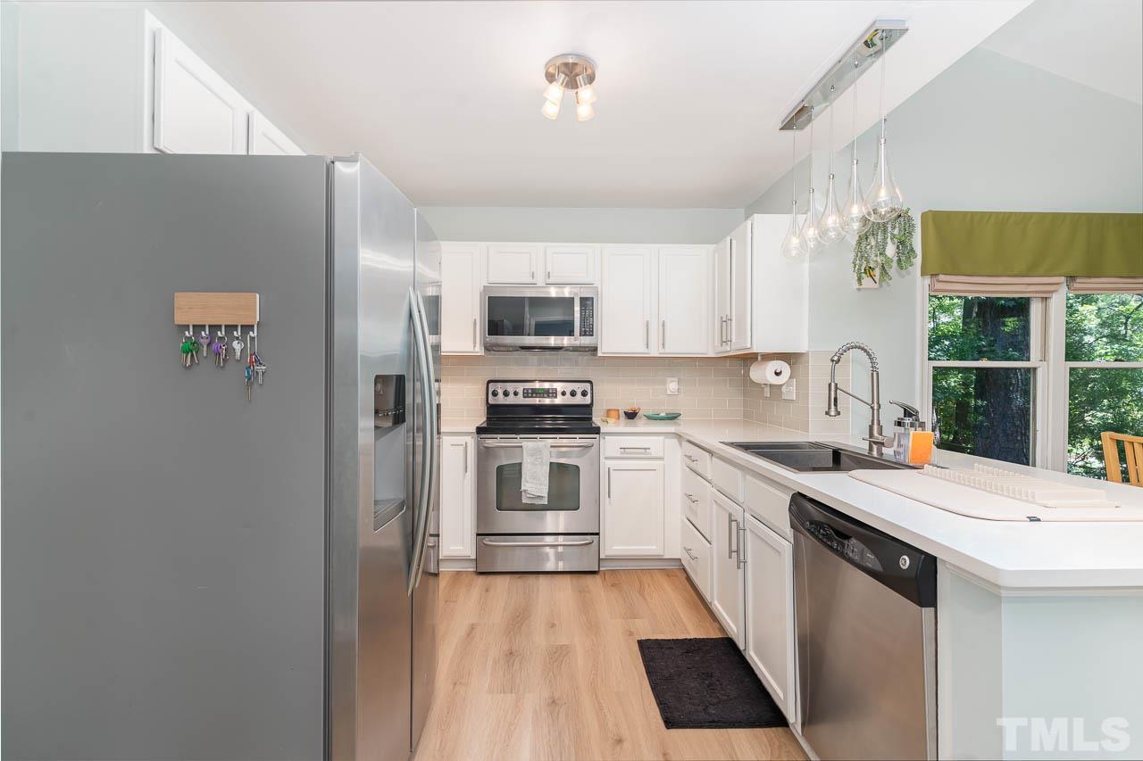 406 Old Fox Trail Durham, NC 27713 - Photo 9 of 23 a kitchen with granite countertop a sink stove and refrigerator