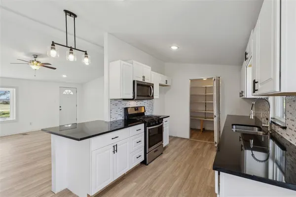 a kitchen with stainless steel appliances a stove sink microwave and cabinets