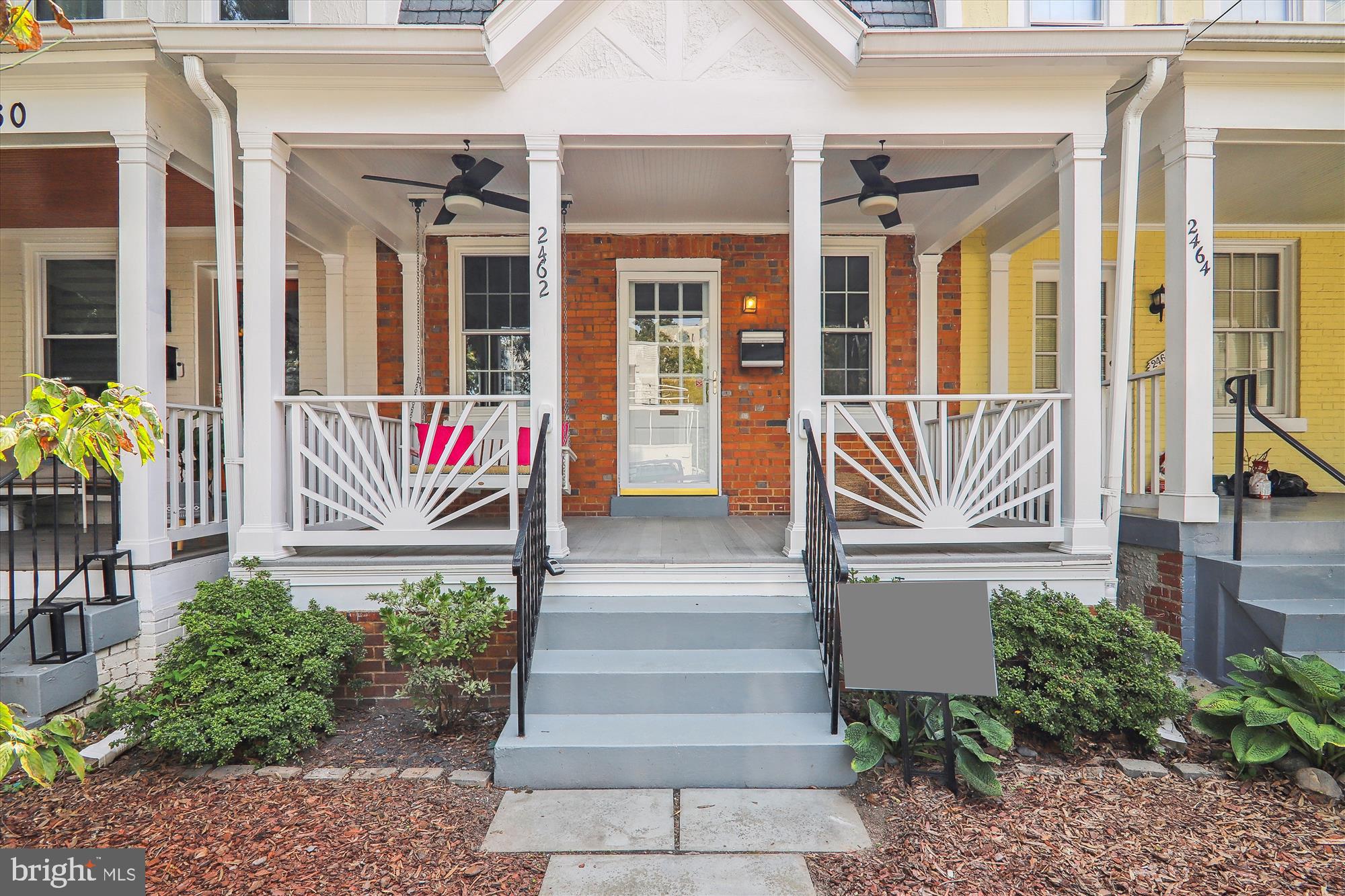 a front view of a house with entryway and potted plants