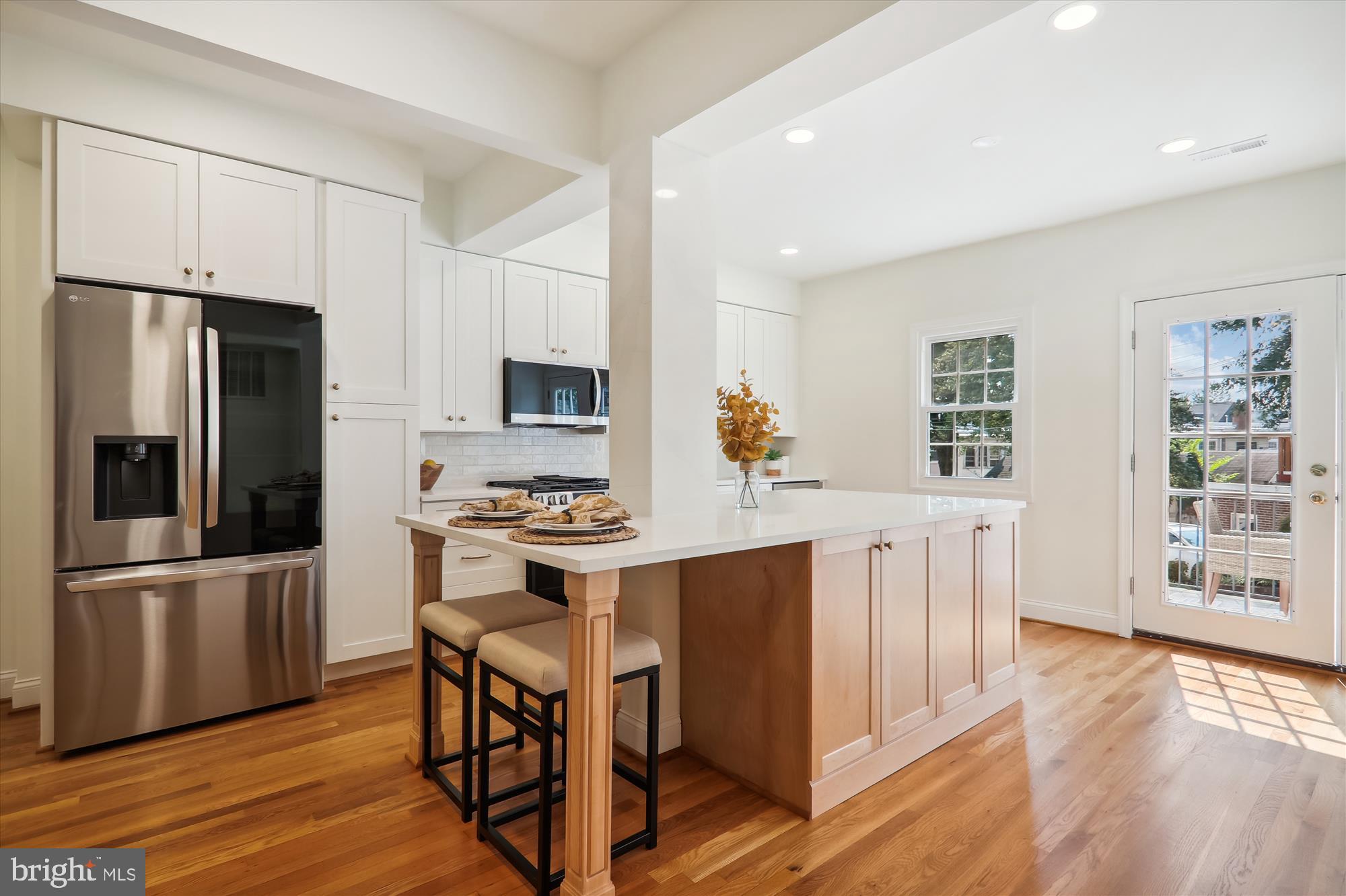 2462 Tunlaw Road Northwest Washington, DC 20007 - Photo 12 of 56 a kitchen with stainless steel appliances a stove a refrigerator a sink a stove and white cabinets with wooden floor