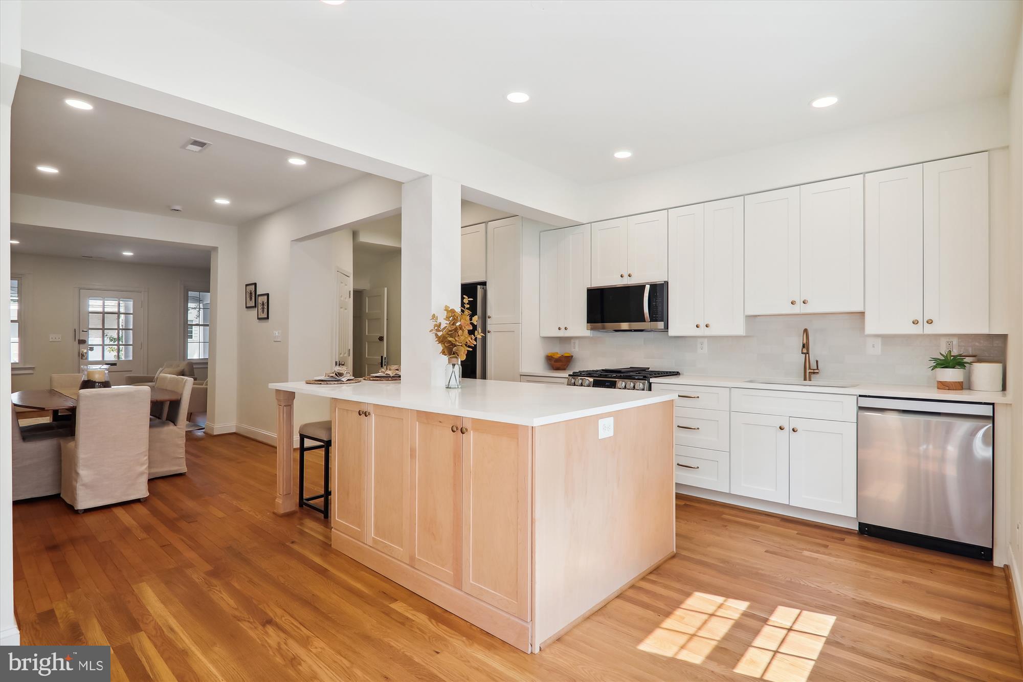 2462 Tunlaw Road Northwest Washington, DC 20007 - Photo 13 of 56 a large kitchen with kitchen island white cabinets and stainless steel appliances