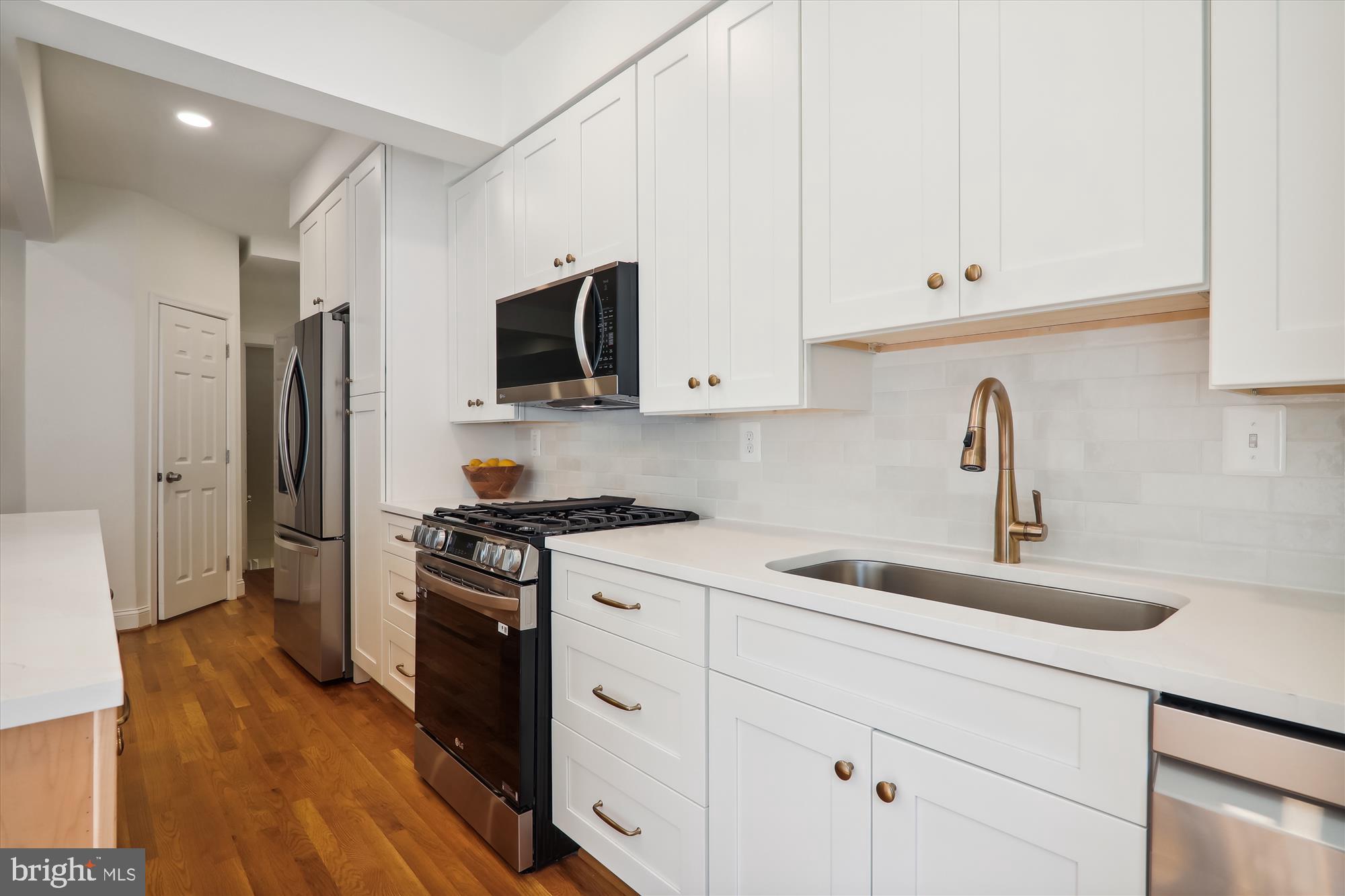 2462 Tunlaw Road Northwest Washington, DC 20007 - Photo 15 of 56 a kitchen with appliances a sink and cabinets
