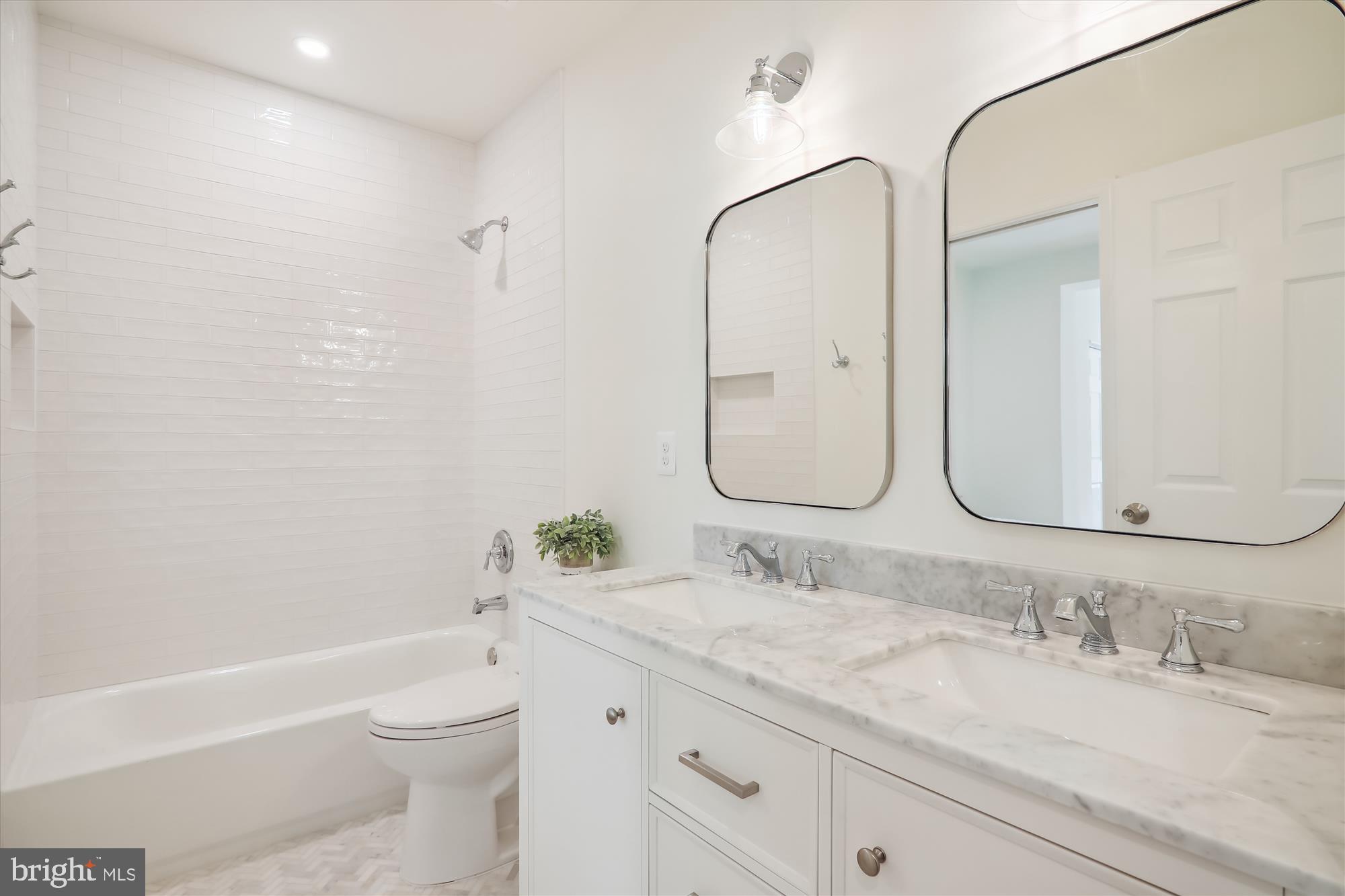 2462 Tunlaw Road Northwest Washington, DC 20007 - Photo 21 of 56 a bathroom with a granite countertop sink a toilet and a mirror