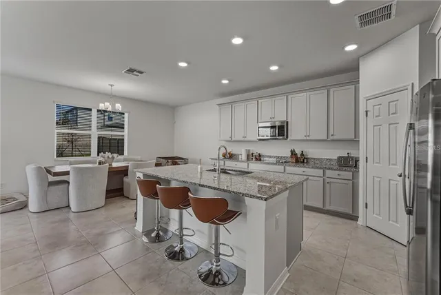 a kitchen with stainless steel appliances granite countertop a refrigerator and a stove top oven