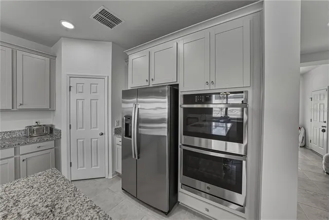a kitchen with stainless steel appliances granite countertop white cabinets and a sink
