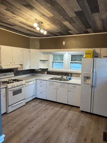 a kitchen with granite countertop white cabinets and white appliances