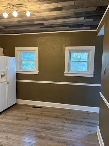 a view of a room with wooden floor and windows