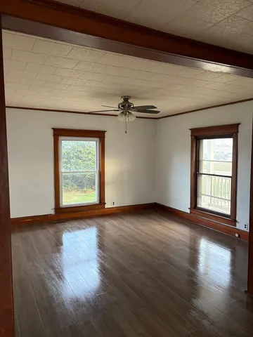 a view of a livingroom with wooden floor and a window