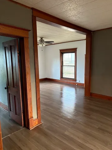 an empty room with wooden floor and a window