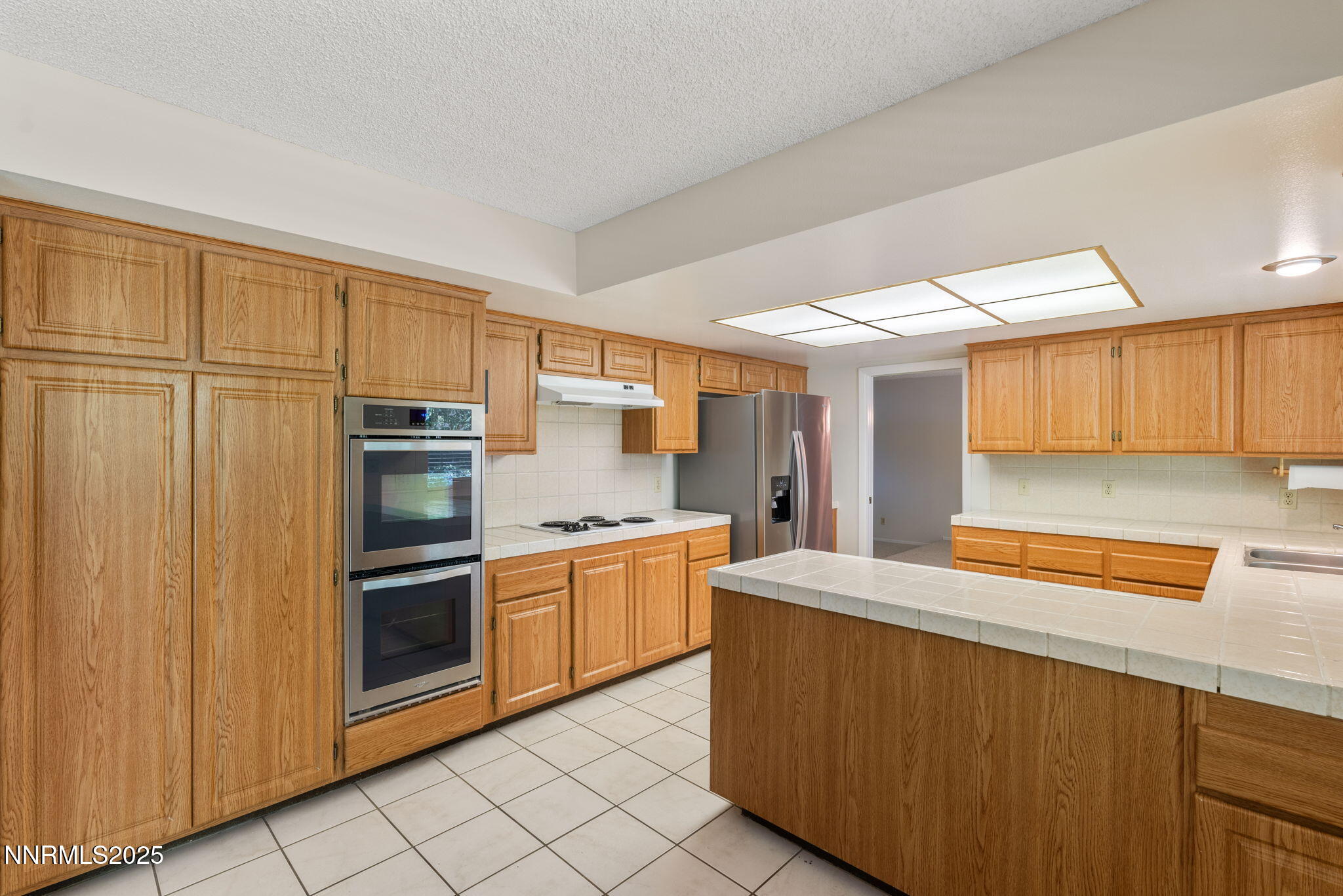 4899 Cool Springs Drive Reno, NV 89509 - Photo 13 of 41 a kitchen with stainless steel appliances granite countertop a refrigerator and a stove top oven