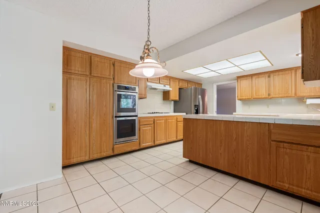 a kitchen with stainless steel appliances granite countertop a stove a sink and a refrigerator