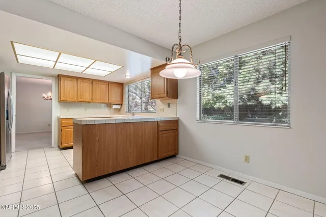 a room with a chandelier and kitchen view