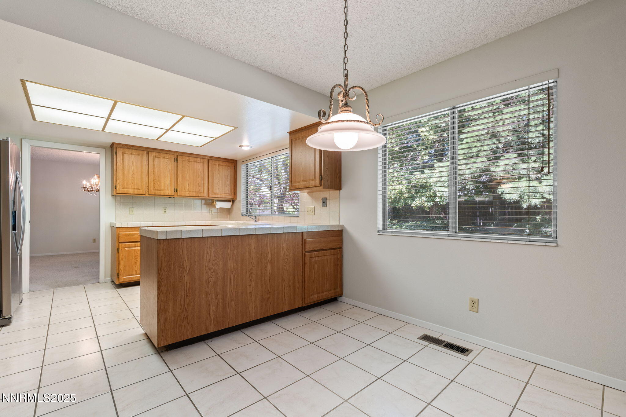 4899 Cool Springs Drive Reno, NV 89509 - Photo 19 of 41 a room with a chandelier and kitchen view
