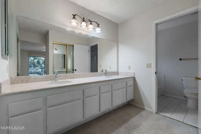 a bathroom with a double vanity sink and a toilet