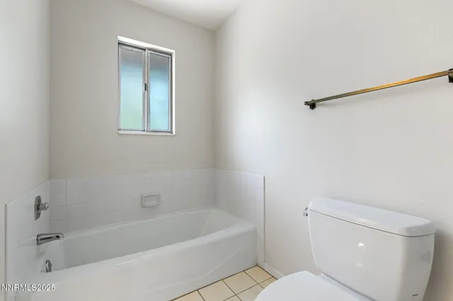 a bath room with a toilet and a bath tub