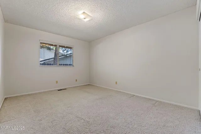 an empty room with a painting on the wall