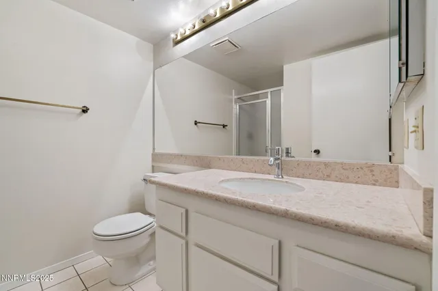 a bathroom with a granite countertop sink a toilet and a mirror