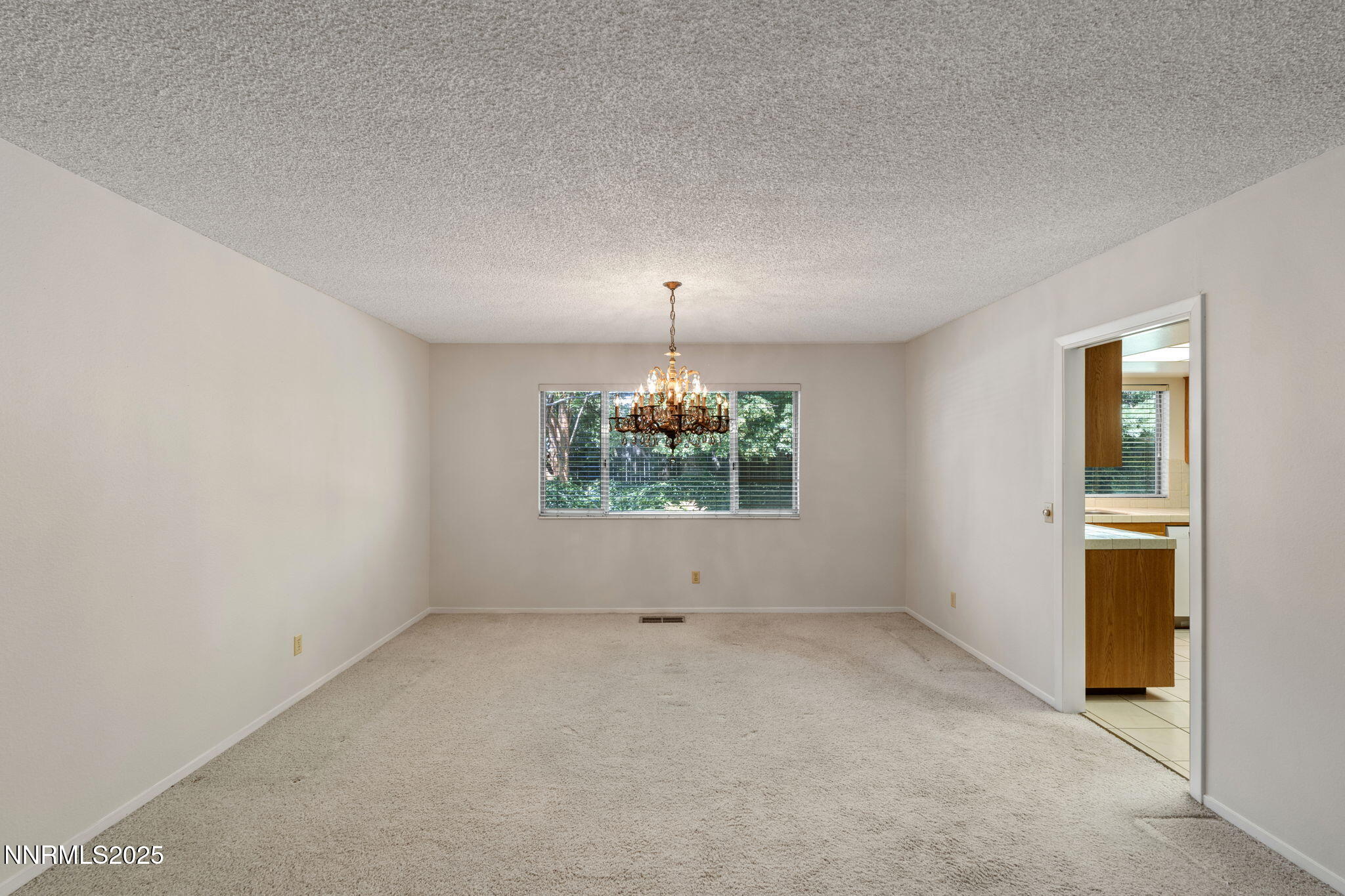 4899 Cool Springs Drive Reno, NV 89509 - Photo 10 of 41 an empty room with windows and chandelier fan