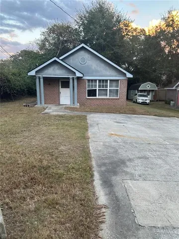 a front view of a house with a garden