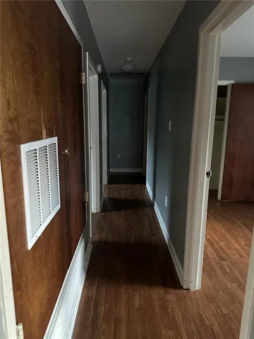 a view of a hallway with wooden floor and staircase