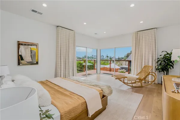 a spacious bedroom with a large bed and a potted plant