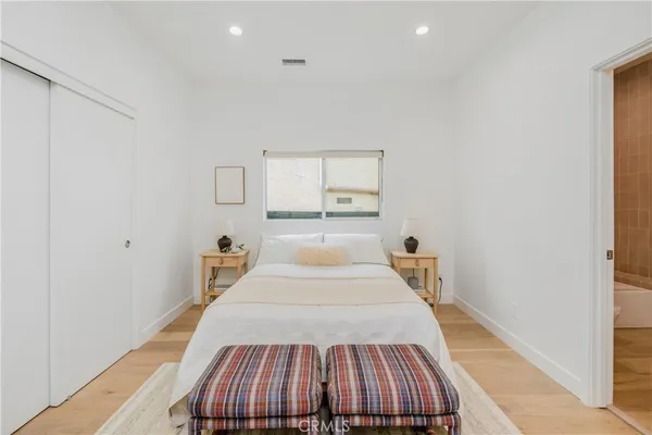 a bedroom with a bed and wooden floor