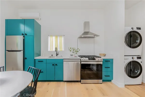 a kitchen with stainless steel appliances granite countertop a stove a washer and dryer