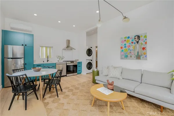 a living room with furniture and a dining table with kitchen view