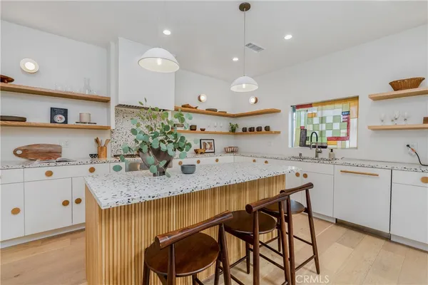 a kitchen with kitchen island granite countertop counter space a sink and appliances