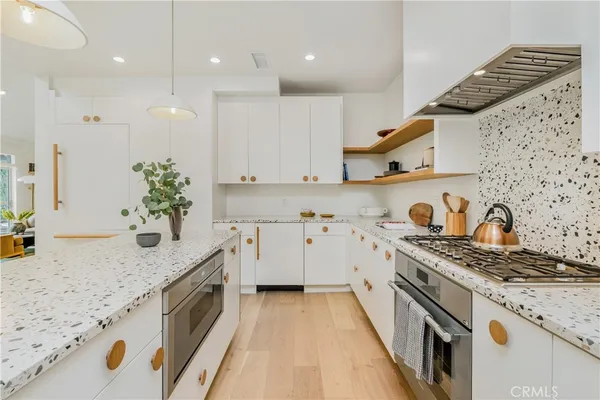 a kitchen with stainless steel appliances granite countertop a sink stove and cabinets