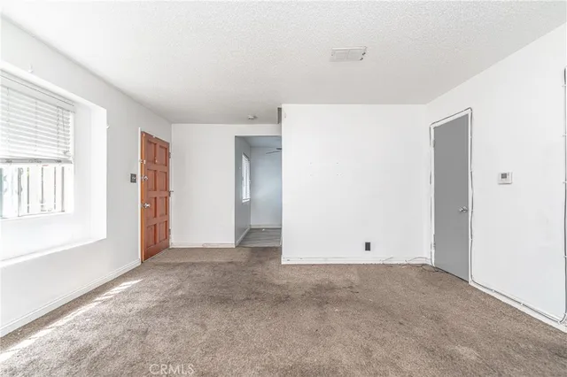 an empty room with windows and closet