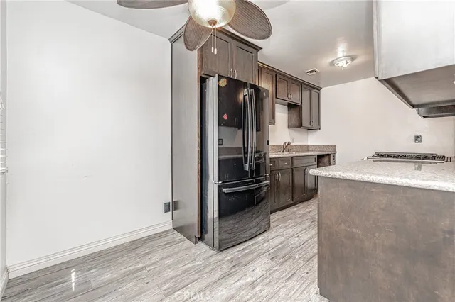 a kitchen with granite countertop a refrigerator and a stove top oven