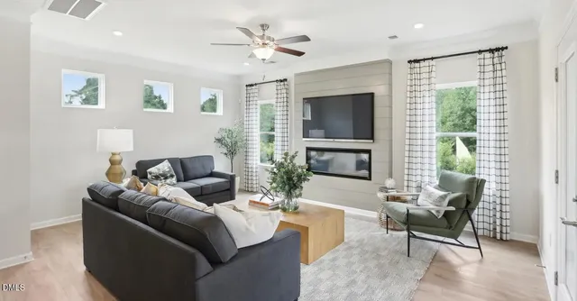 a living room with furniture a flat screen tv and a large window