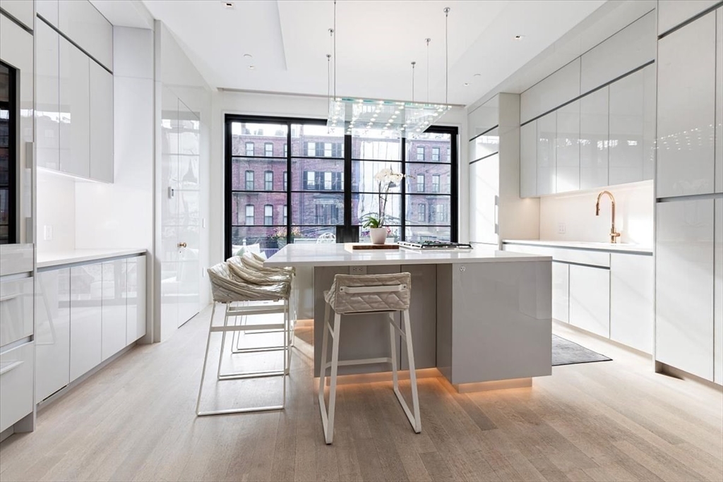 a kitchen with a table chairs refrigerator and cabinets